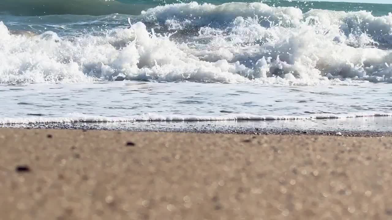 美丽的蓝色大海和巨大的平静的波浪和泡沫。海浪拍打着海上的鹅卵石。翻滚的海浪。夏日天堂海滩背景。强大的海浪视频素材