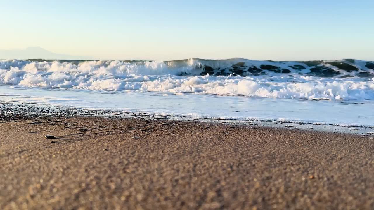 美丽的蓝色大海和巨大的平静的波浪和泡沫。海浪拍打着海上的鹅卵石。翻滚的海浪。夏日天堂海滩背景。强大的海浪视频素材