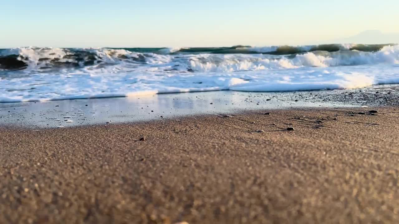 美丽的蓝色大海和巨大的平静的波浪和泡沫。海浪拍打着海上的鹅卵石。翻滚的海浪。夏日天堂海滩背景。强大的海浪视频素材