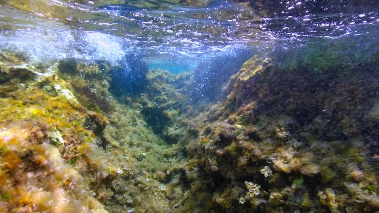 岩石海岸附近海浪的水下景观。视频素材