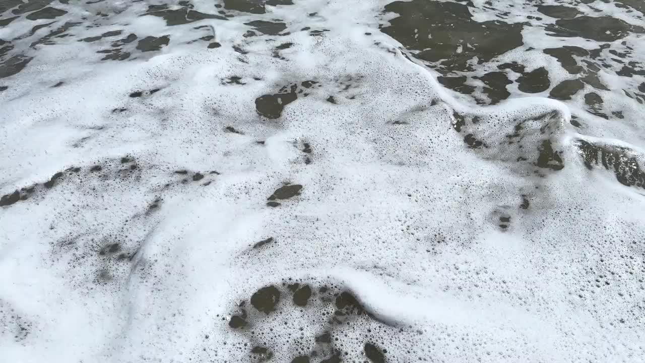 有泡沫的平静巨浪。海浪拍打着海上的鹅卵石。翻滚的海浪。夏日天堂海滩背景。强大的海浪视频下载