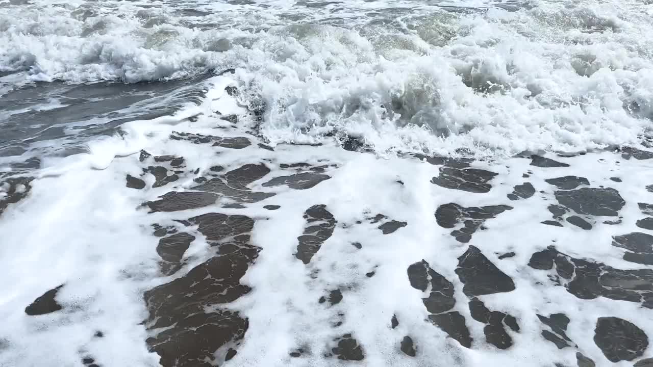 有泡沫的平静巨浪。海浪拍打着海上的鹅卵石。翻滚的海浪。夏日天堂海滩背景。强大的海浪视频下载