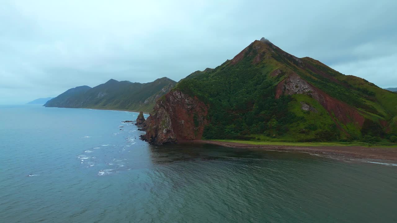 在多云的日子里，山的海岸和岩石的俯视图。夹。阴天的海、山、岛的美丽景观。迷人的北部海岸景观，有大海和岩石视频素材