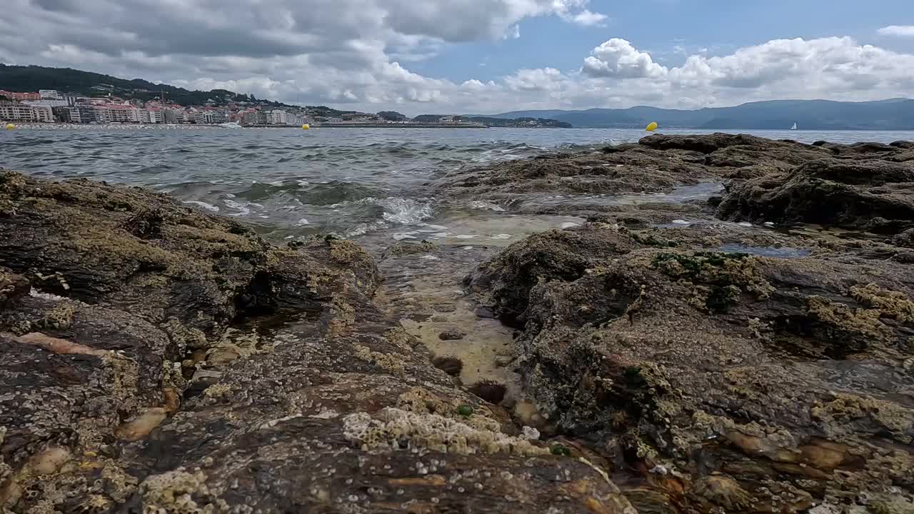 海浪溅在地面的相机上，背景是城市的景色视频下载