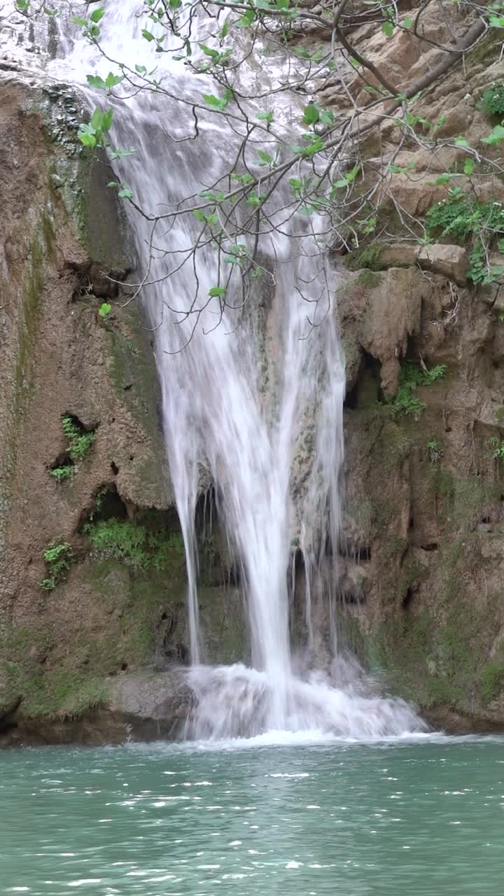 山河瀑布的溪水落入山湖垂直景观视频素材