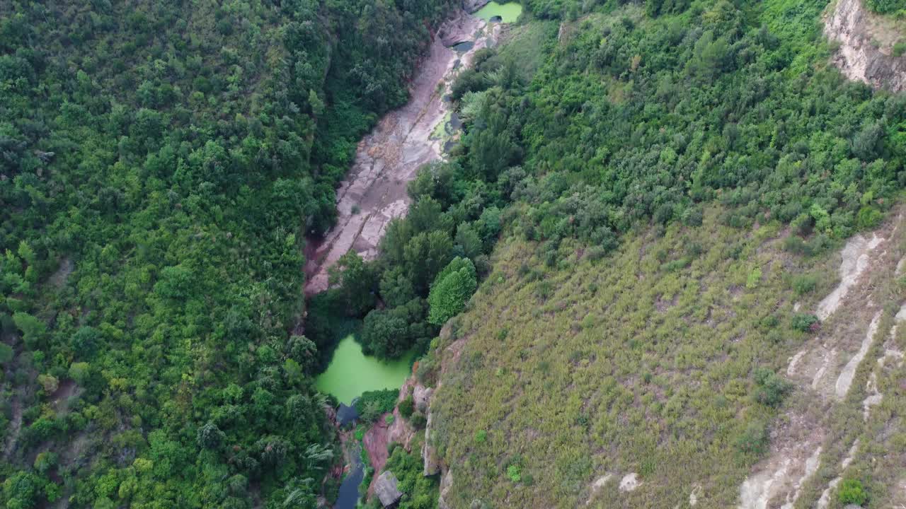 圣米格尔del fai与郁郁葱葱的绿色和河流通过岩石地形，巴塞罗那，鸟瞰图视频素材