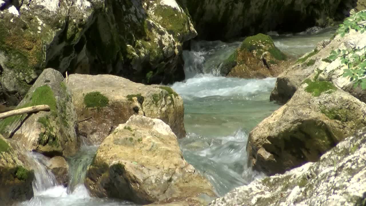 在炎热的夏天，湍急的河流，美丽的高山河流穿过岩石的特写视频素材