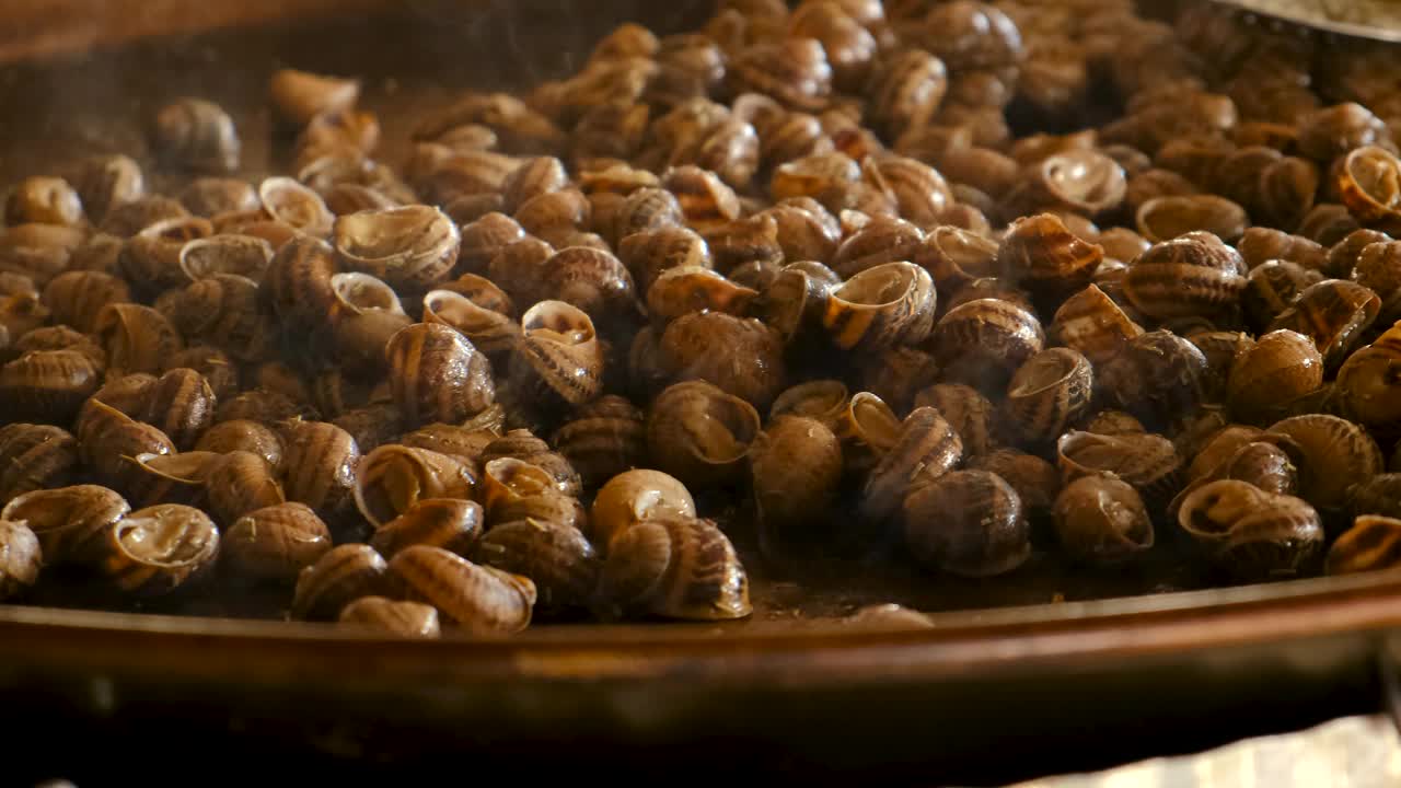 在煎锅里煮很多蜗牛。有选择性的重点。食物。视频素材
