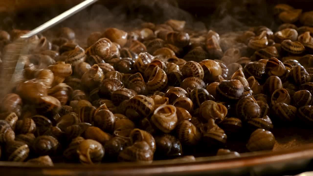 在煎锅里煮很多蜗牛。有选择性的重点。食物。视频素材