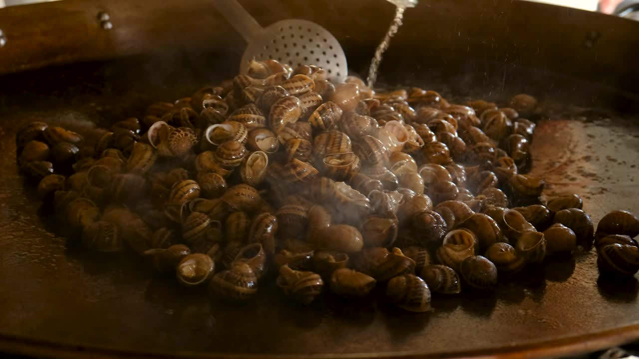 在煎锅里煮很多蜗牛。有选择性的重点。食物。视频下载