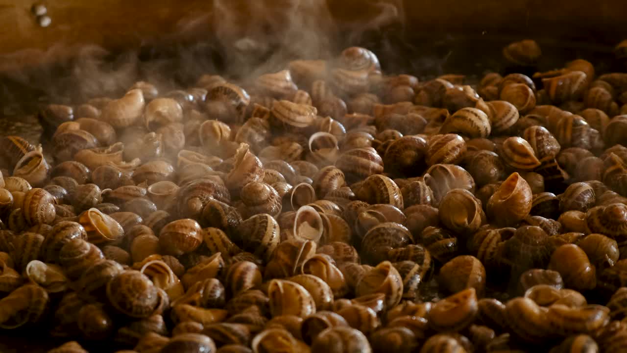 在煎锅里煮很多蜗牛。有选择性的重点。食物。视频下载