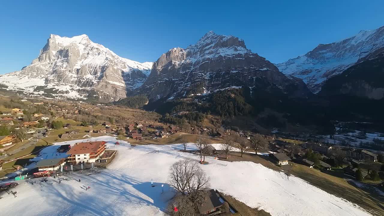 从空中俯瞰瑞士阿尔卑斯山的格林德瓦尔德滑雪胜地。瑞士冬末积雪融化时的高山景观。视频素材