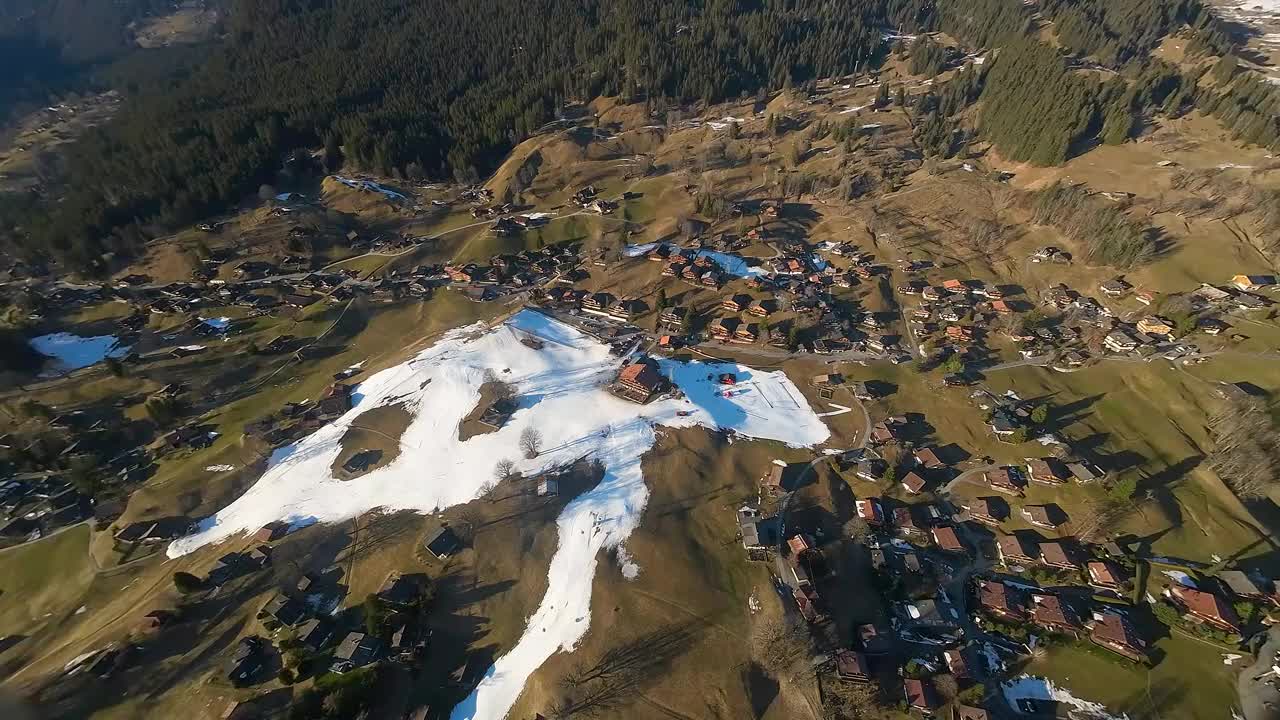 俯瞰格林德沃，瑞士，滑雪坡和住房。瑞士阿尔卑斯山的冬天，地面上的雪很少。全球变暖对滑雪产业概念的影响。视频素材