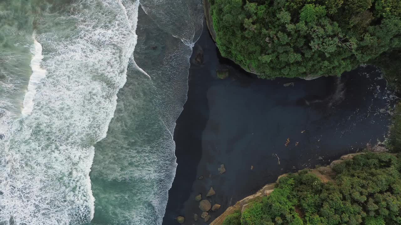 海浪到达岩石海滩的鸟瞰图，4K镜头视频素材