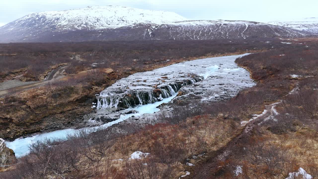 从空中俯瞰，冰岛冰雪覆盖的岩石中有瀑布视频素材