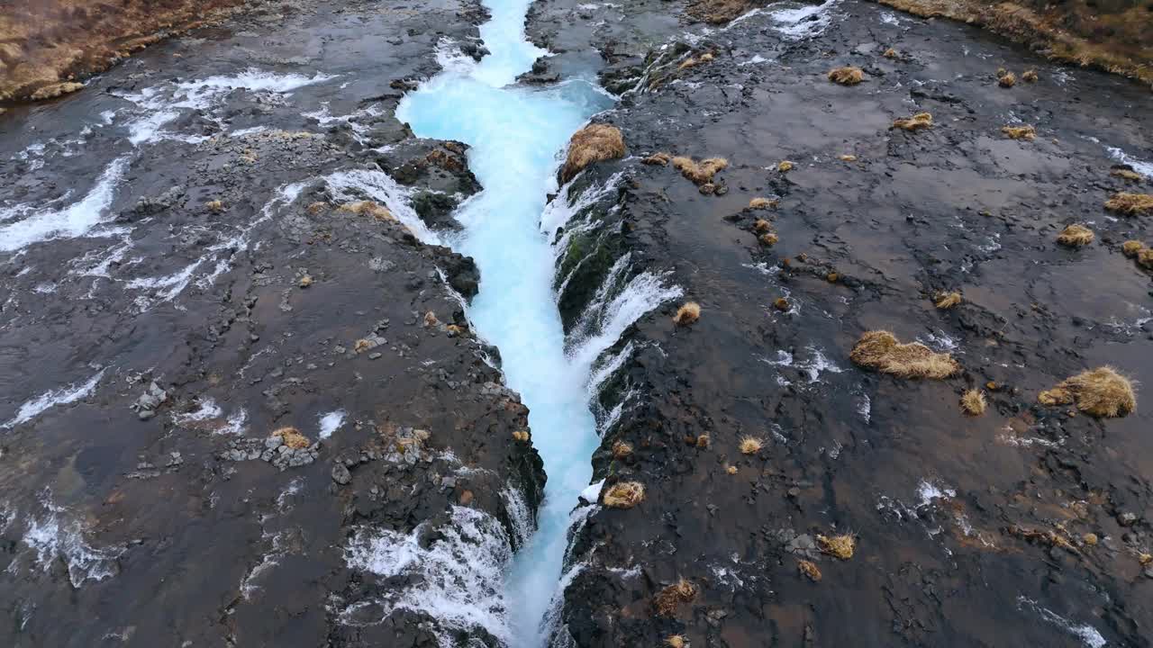 布鲁尔福斯瀑布的绿松石般的水从冰岛的火山岩中倾泻而下视频素材