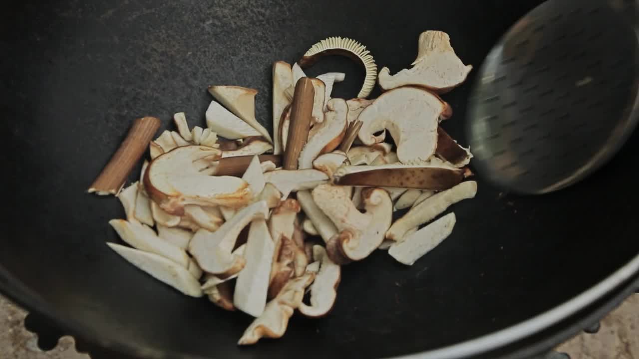 用煎锅煎香菇。煮蘑菇，特写女人的手视频素材