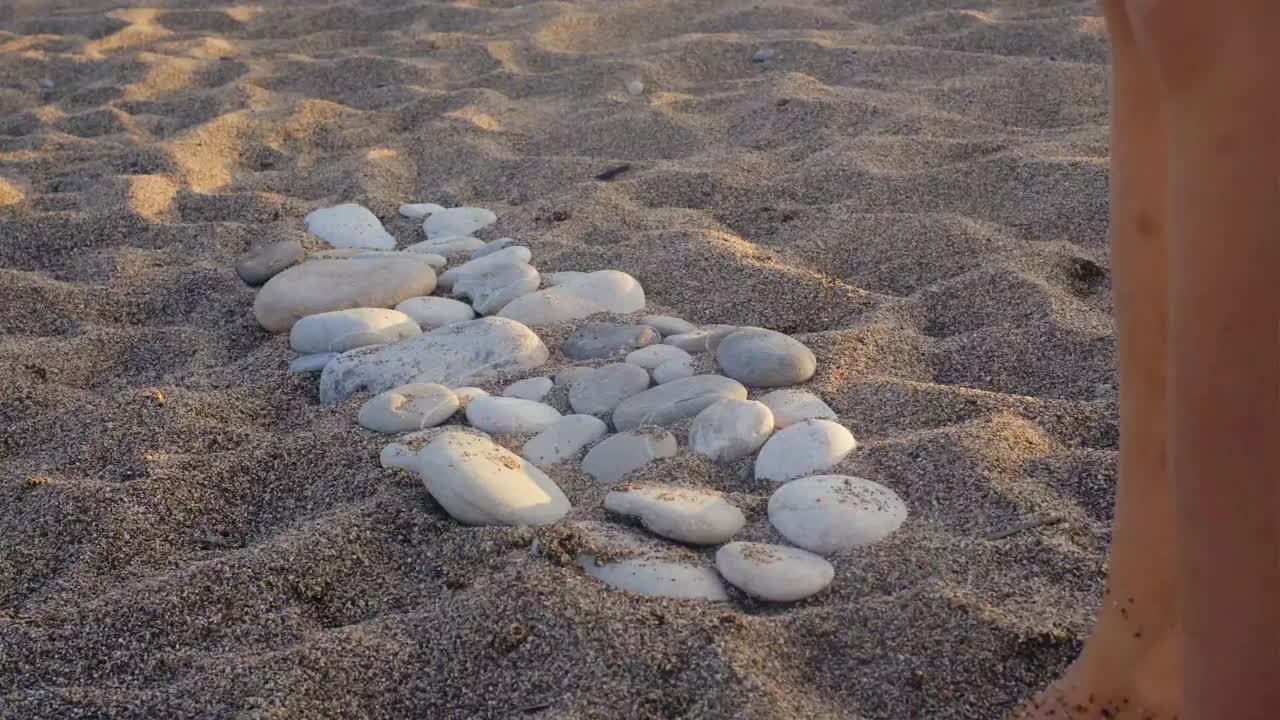 脚在海滩岩石上行走的视频。矫正扁平足、足部疾病。在沙滩上给孩子做足部按摩。骨科医生腿部特写视频下载