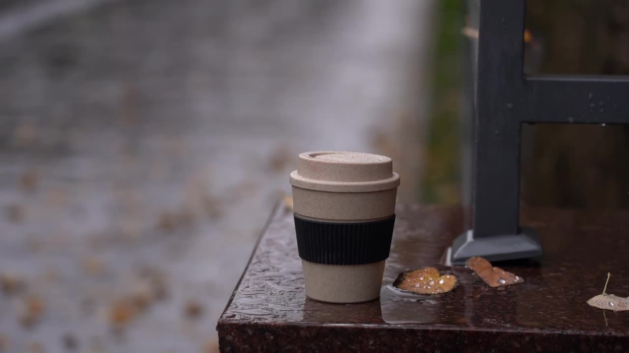 天冷时喝热饮。秋雨下的秋叶和咖啡杯视频下载