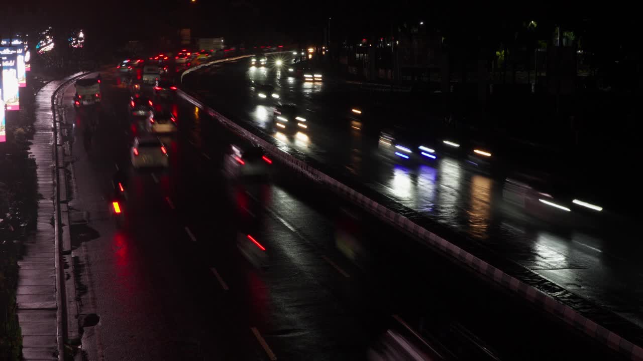 用慢速快门捕捉雨后光滑道路上的夜间交通视频素材