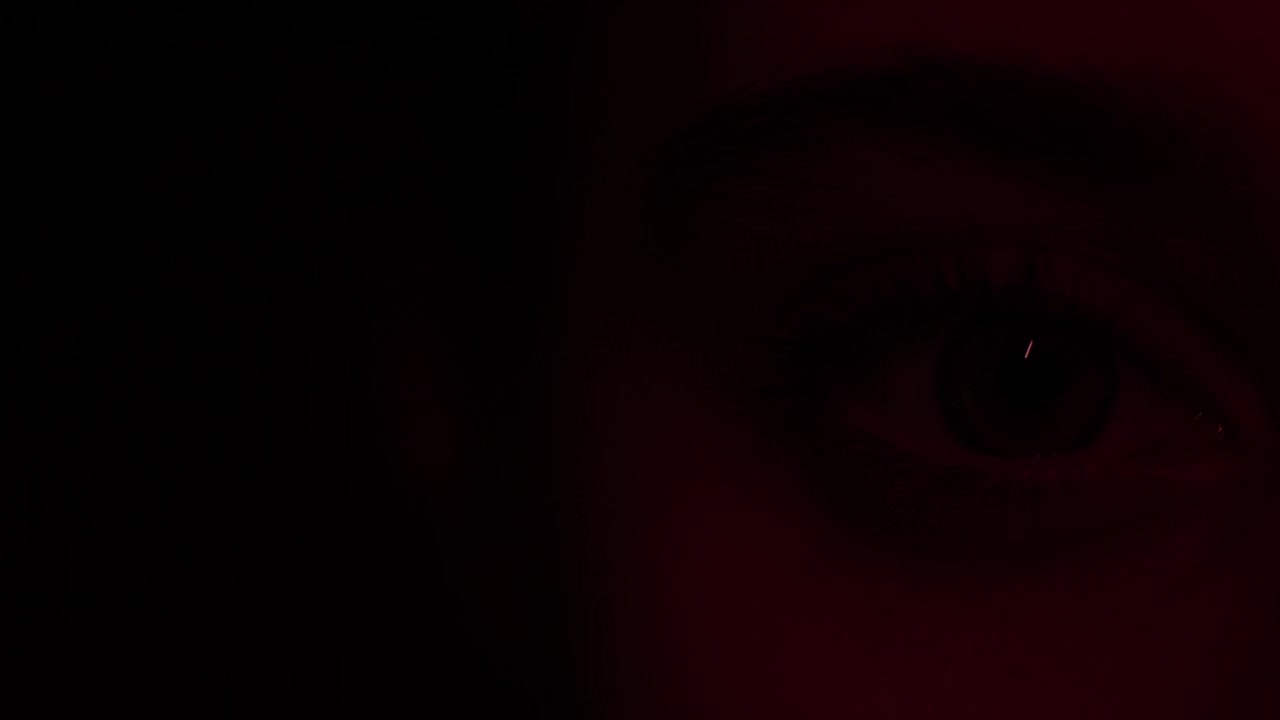红光下少女的眼睛特写视频下载