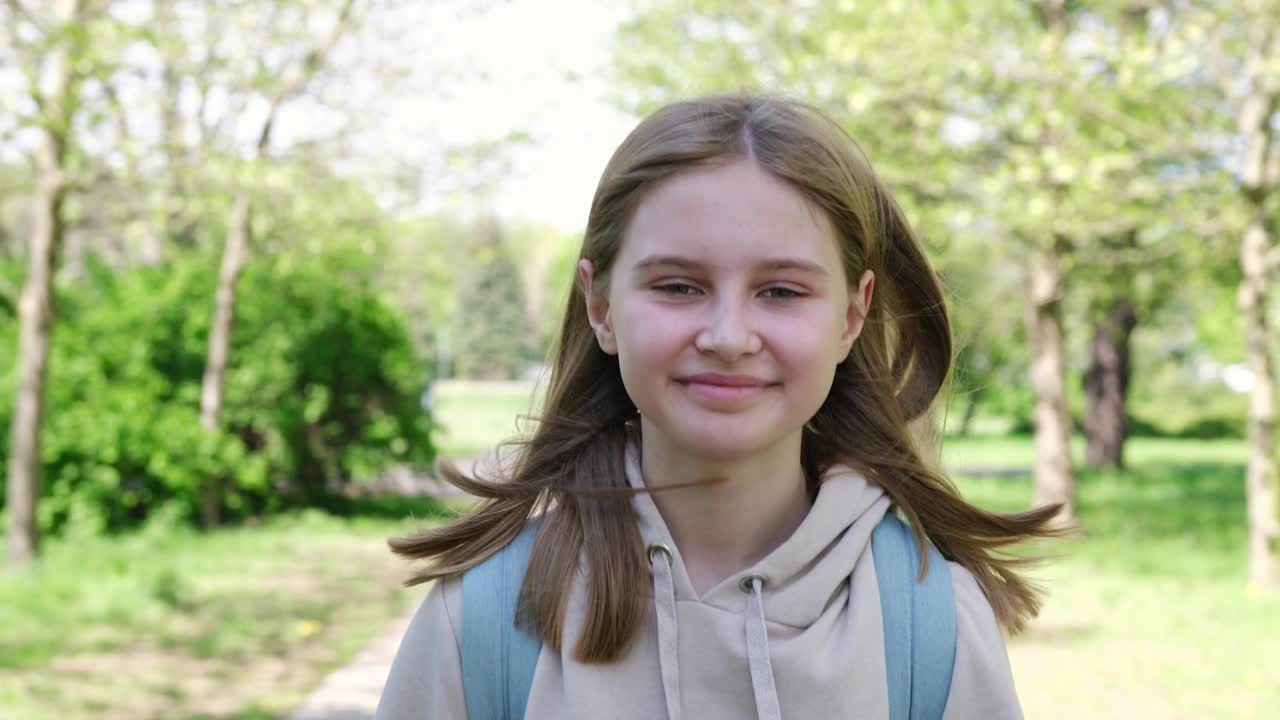 可爱的小女孩放学后在公园散步的肖像视频素材