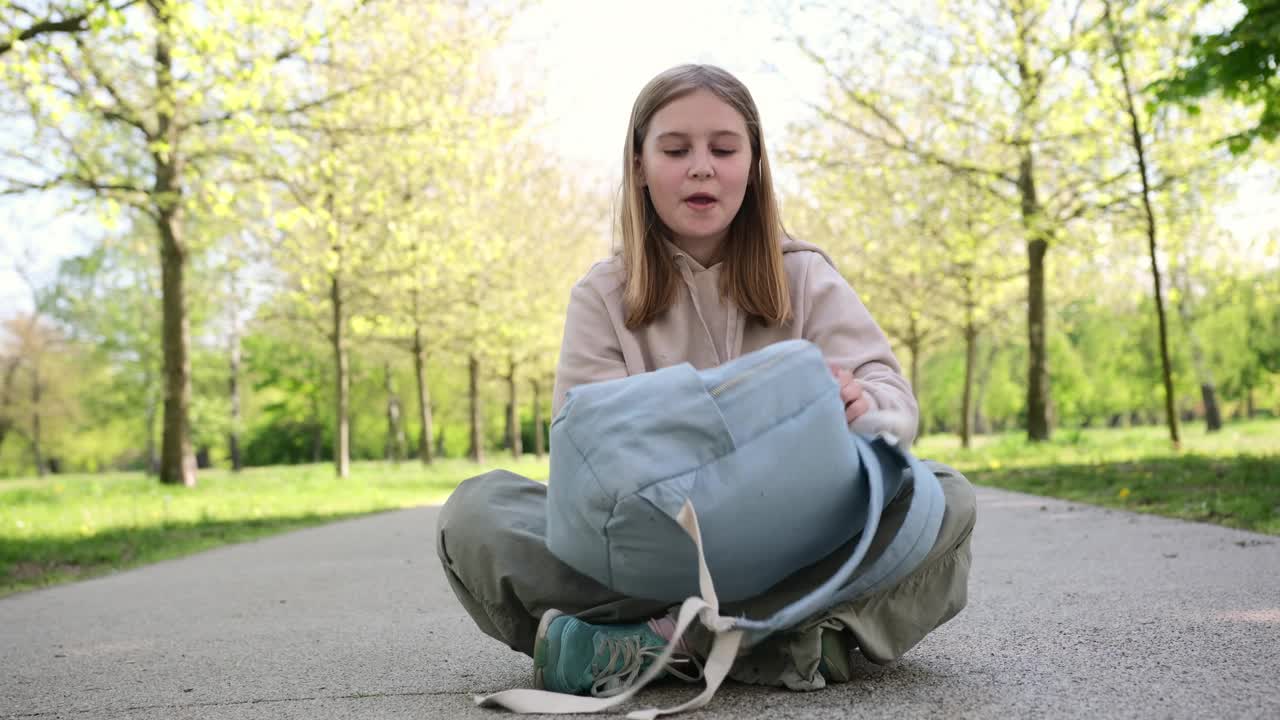 快乐的小女孩放学后在公园里玩她的背包视频素材