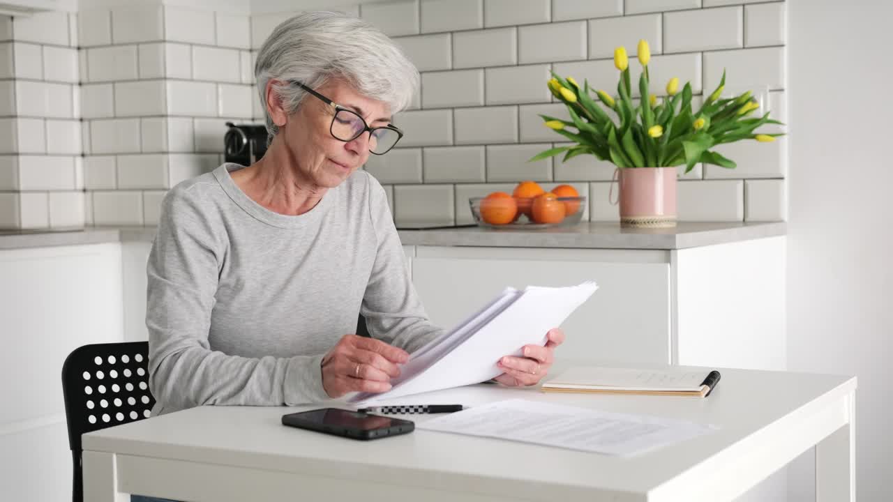 老年退休妇女在信用合同中计算付款金额视频下载