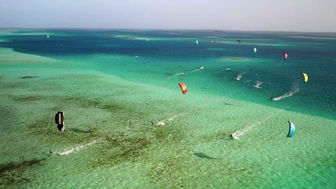 一个充满活力的风筝冲浪场景在热带绿松石海，鸟瞰图视频素材