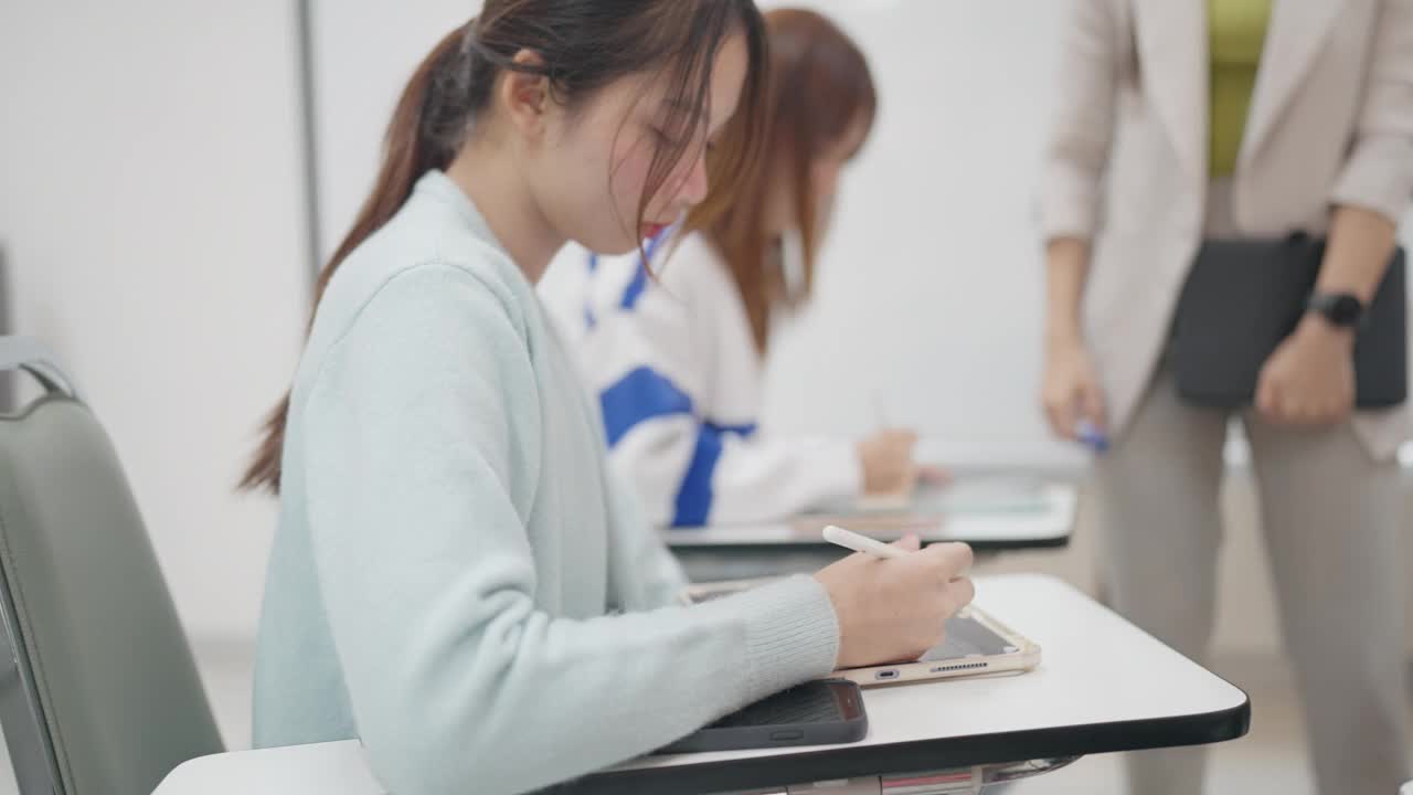 一个女人坐在桌子前，手里拿着一块写字板和一支笔视频素材