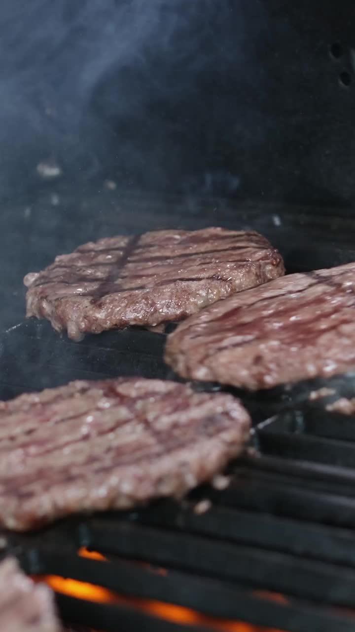 在烤架上烤牛排烤肉排在火热的烤架上做汉堡用的美味的肉。不健康，但非常令人满意的蛋白质美味汉堡在休闲酒吧视频素材