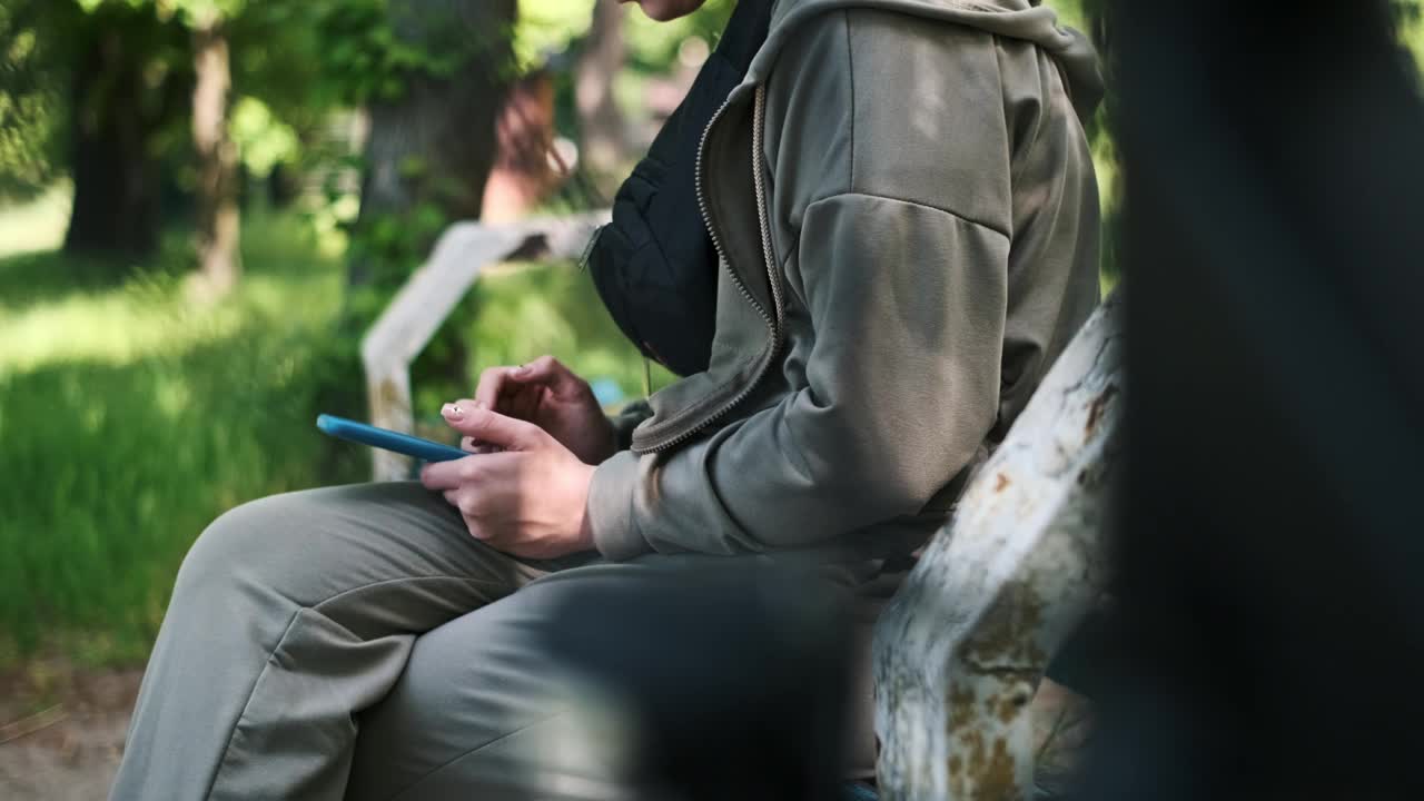 一名女子在公园的湖边使用智能手机视频素材