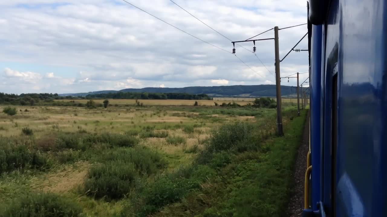 一列火车正穿过一片田野，背景是蓝色的天空视频素材