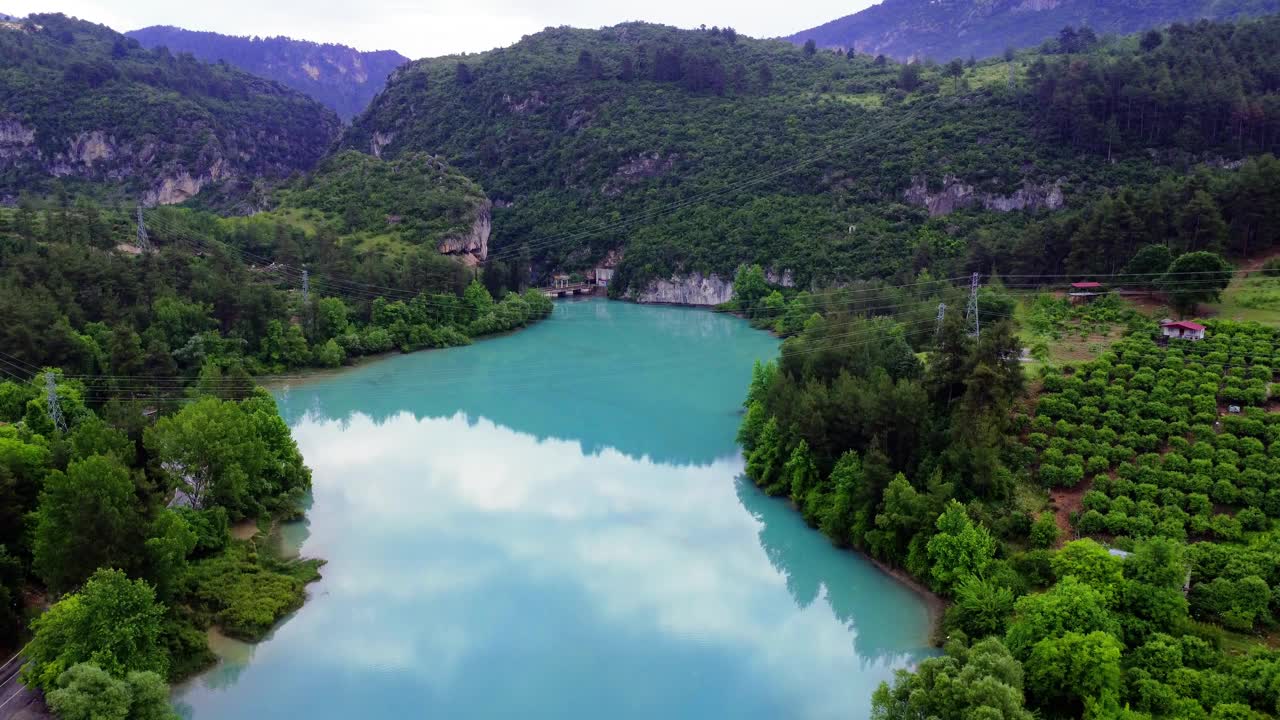 发现一个宁静的山湖坐落在参天大树和雄伟的山峰茂密的森林视频素材