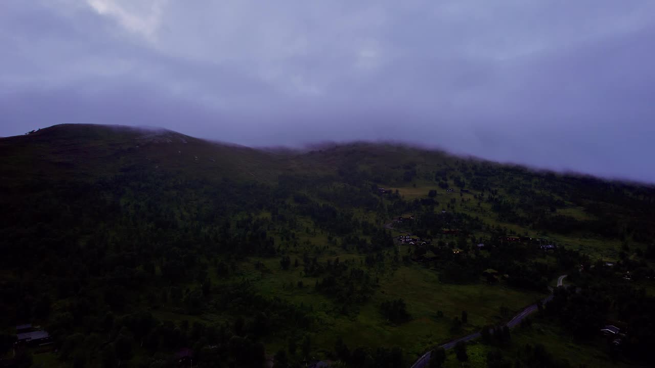 黎明时分，挪威山坡上的雨云与小屋和湖泊视频素材