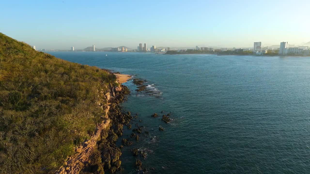 从委内瑞拉岛(Isla de los Venados)拍摄的航拍视频Mazatlán在黎明时分，突出了广阔的海洋、晨流和沿着岩石岛风景如画的海岸线飞行的众多鸟类。视频素材