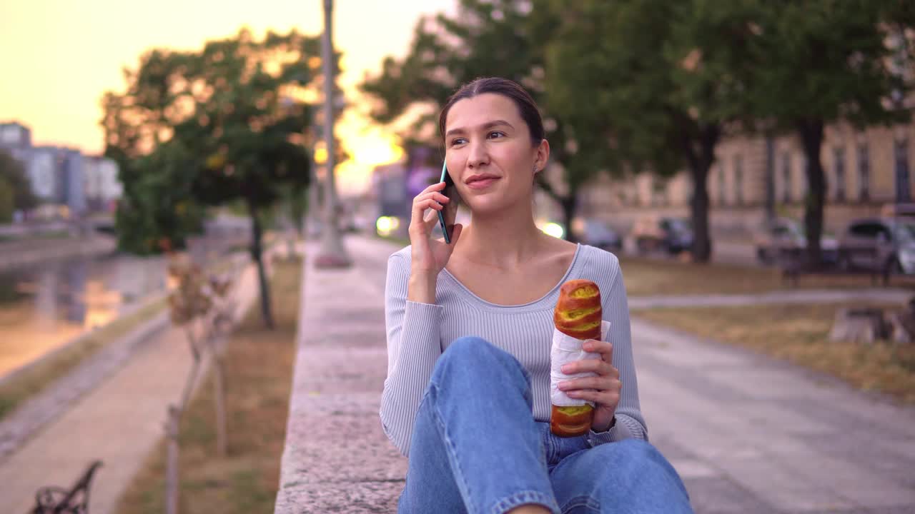 女人一边吃糕点一边讲手机视频素材