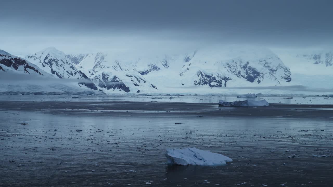 黑暗阴沉的冬季海岸海景，南极海洋风景与冰山山脉和海洋，美丽的戏剧性的蓝色海岸景观在南极半岛，冰冷的冬季海景与冰视频素材