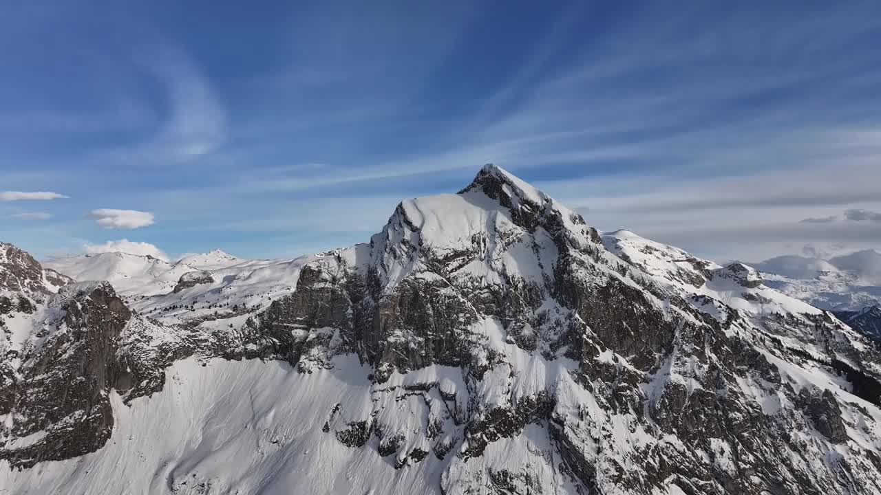 瑞士格拉鲁斯北部，积雪覆盖的Fronalpstock山峰鸟瞰图，峭壁崎岖，天空湛蓝视频素材