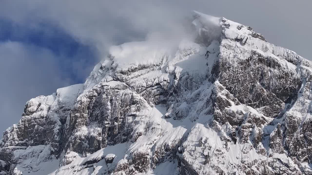 瑞士格拉鲁斯北部多云的天空下，崎岖不平、白雪覆盖的弗朗阿尔普斯托克山峰的航拍图视频素材