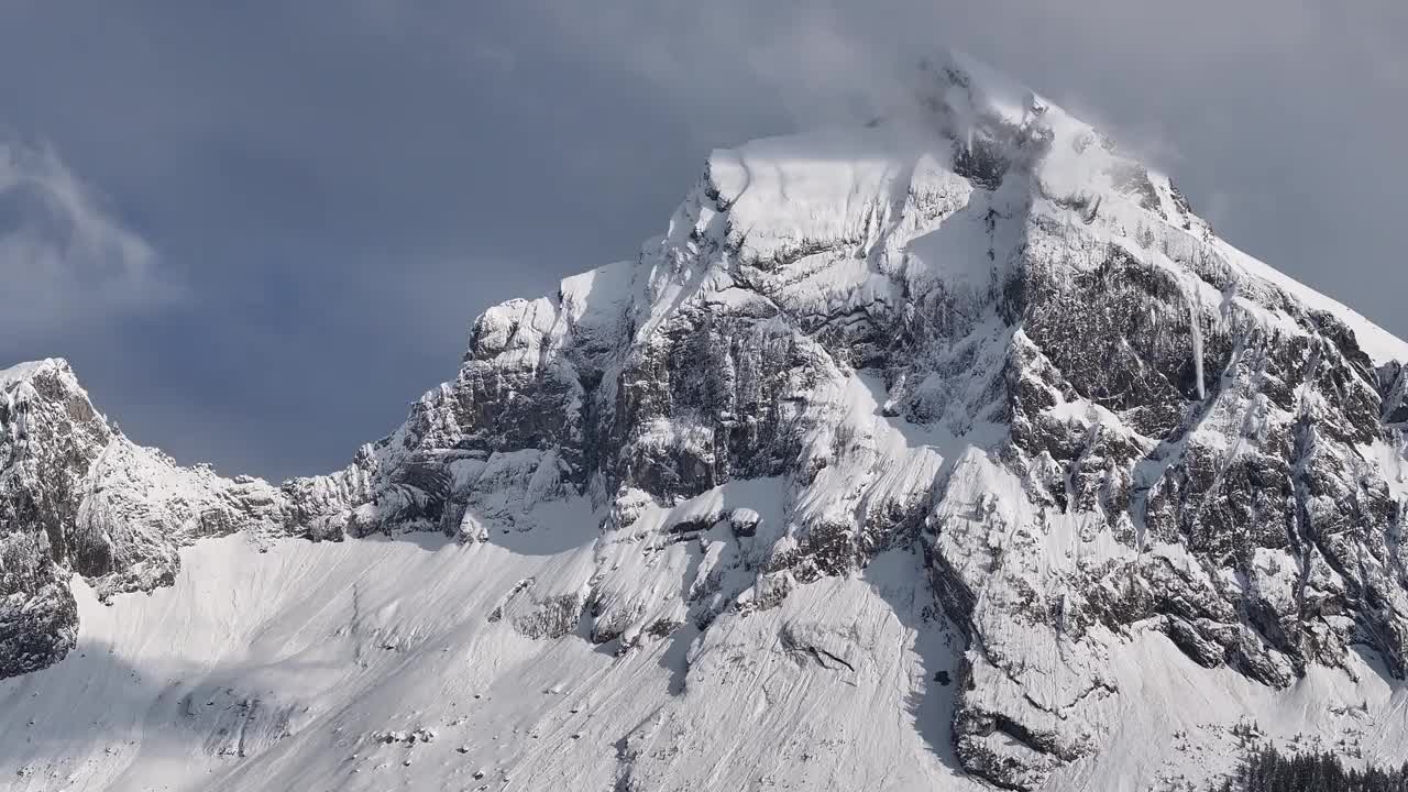 瑞士格拉鲁斯北部，积雪覆盖的Fronalpstock山峰鸟瞰图，峭壁崎岖，天空部分多云视频素材