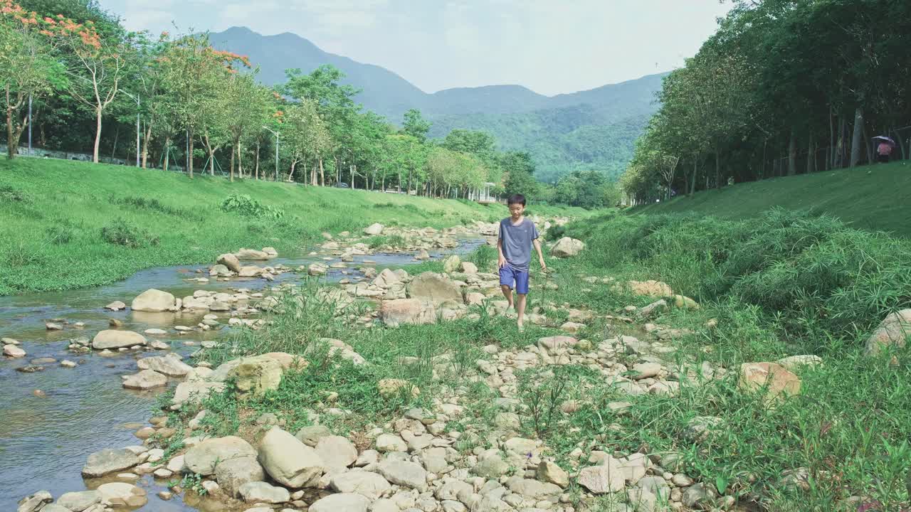 小男孩在河边玩耍视频素材