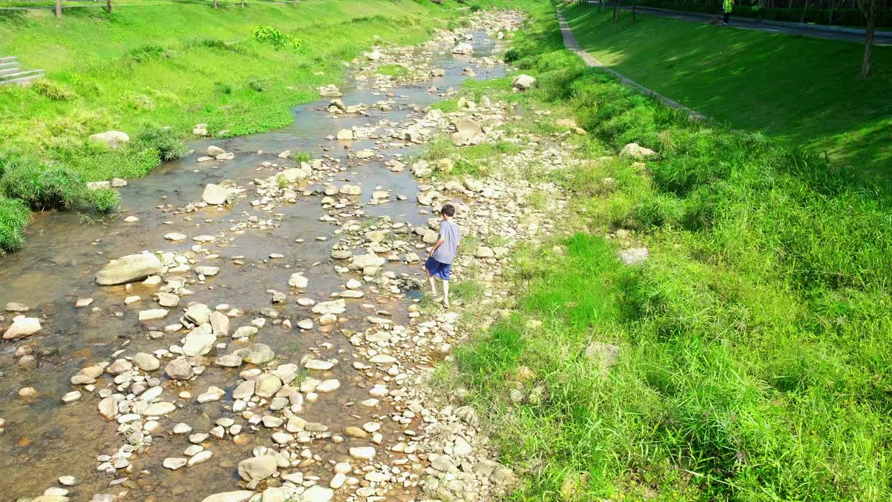 小男孩在河边玩耍视频素材