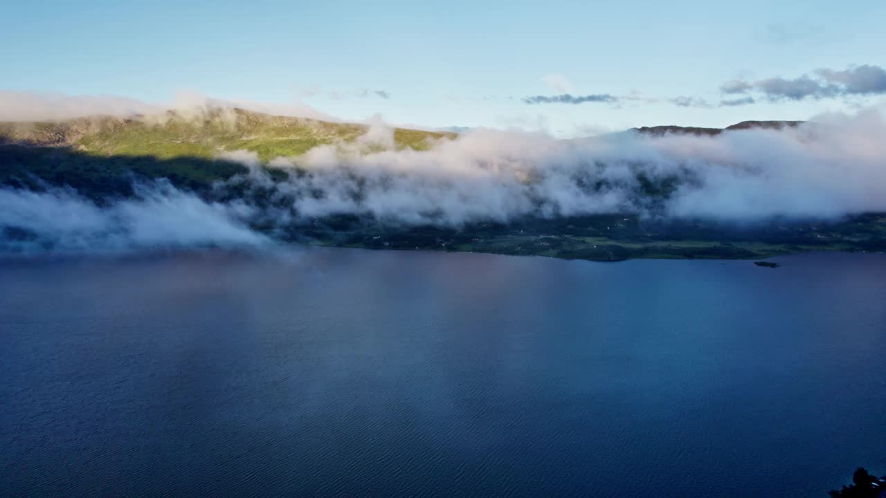 空中滑行拍摄壮丽的Skarvatnet山湖在挪威日落与过往的云视频素材