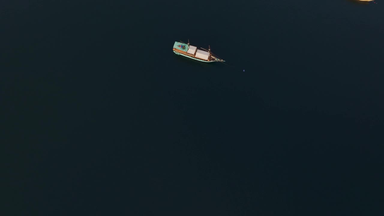 鸟瞰宁静的船在黑暗的海水，弗洛雷斯海，印度尼西亚。视频素材