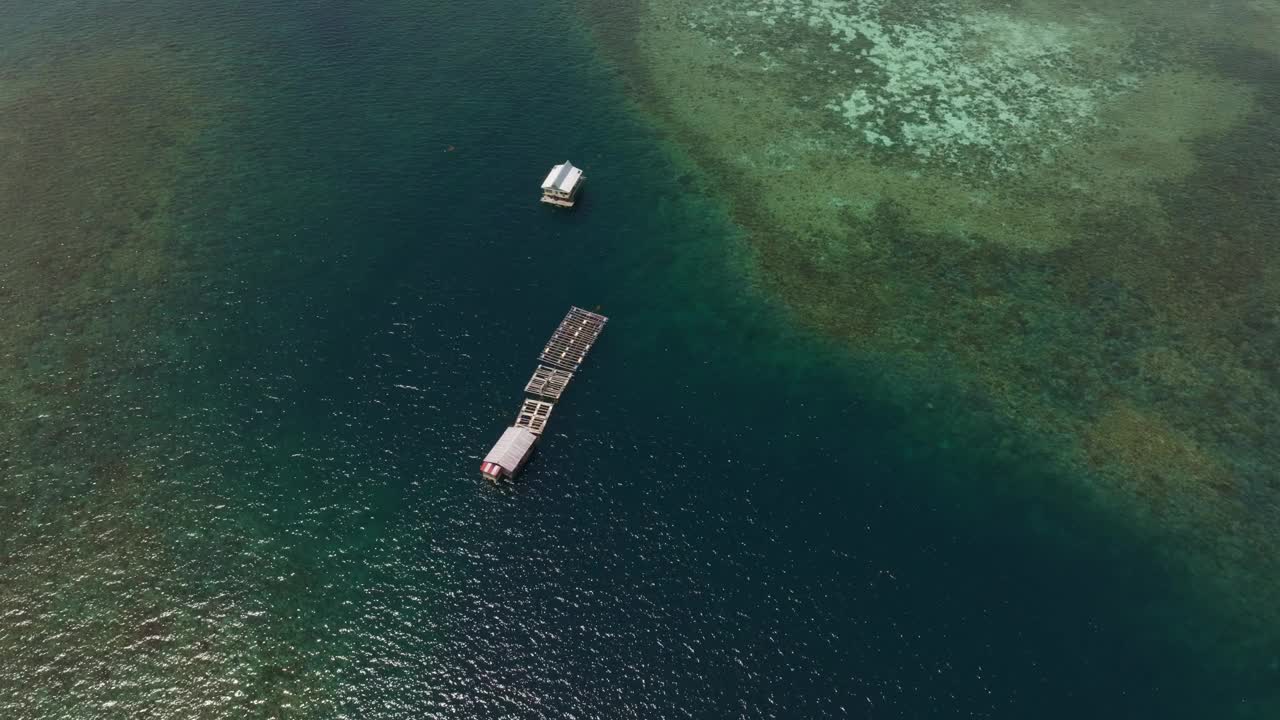 鸟瞰印尼科莫多岛清澈碧蓝的水面上宁静的漂浮房屋。视频素材