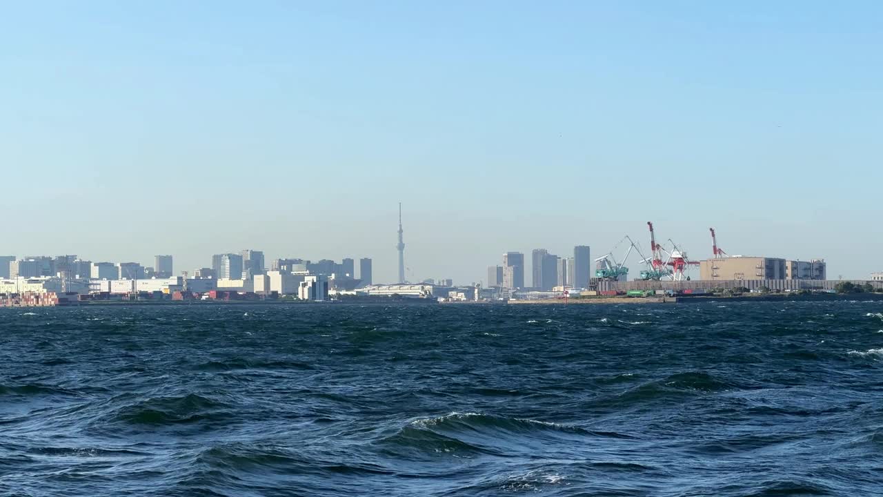 城市的天际线和工业港口看到波涛汹涌的蓝色海水，晴朗的天空视频素材