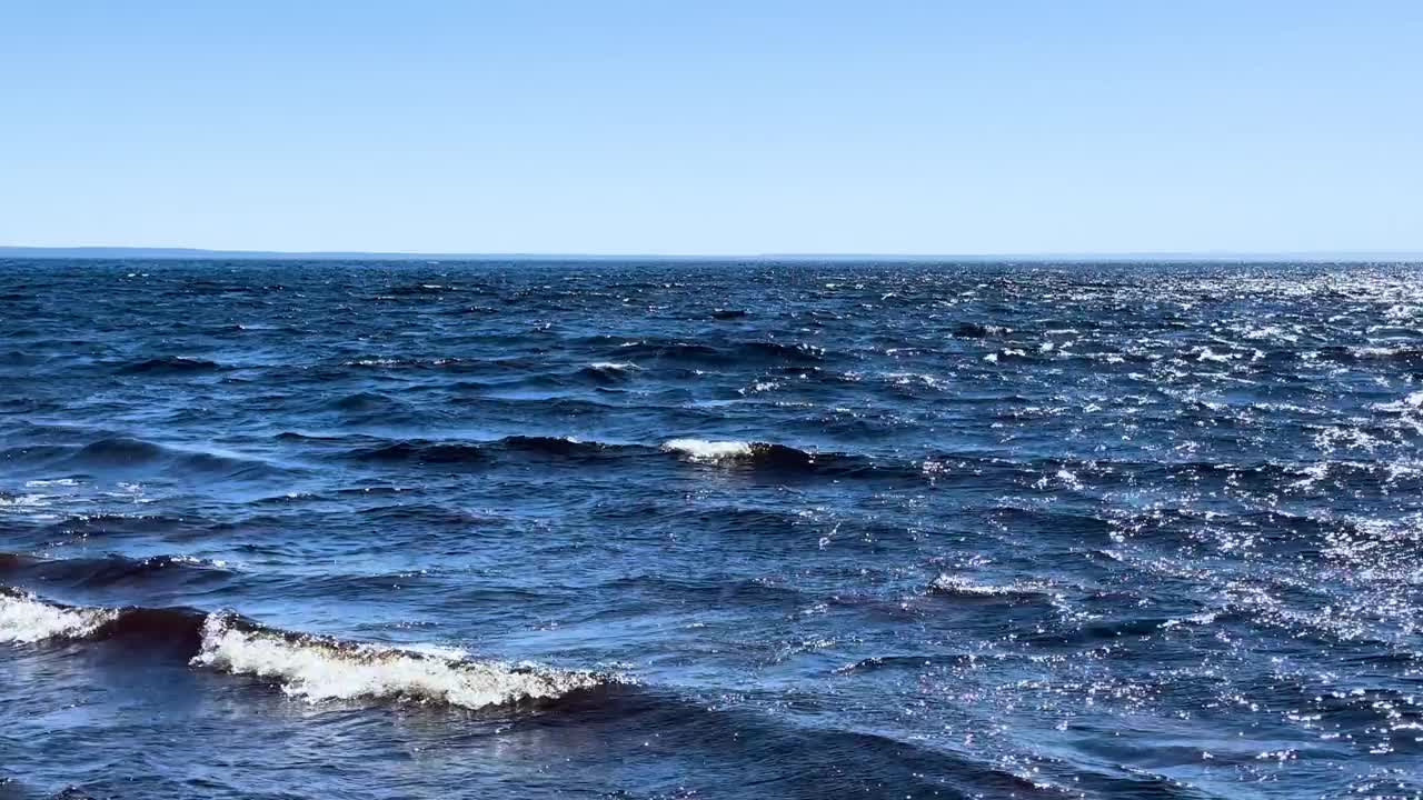 蓝色的大海和平静的大浪。海浪拍打着海上的鹅卵石。翻滚的海浪。夏日天堂海滩背景。强大的海浪视频素材