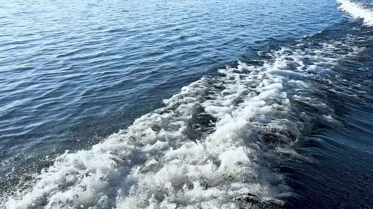 移动的渔船在海面上溅起水花。海洋海水波浪反射。海上的摩托艇视频素材