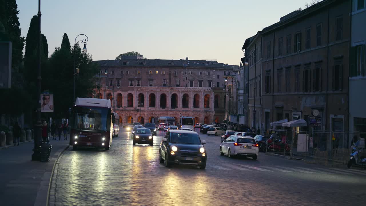 罗马，黄昏时分，罗马鹅卵石街道上繁忙的交通，背景是马塞洛剧院的地标，慢动作视频素材